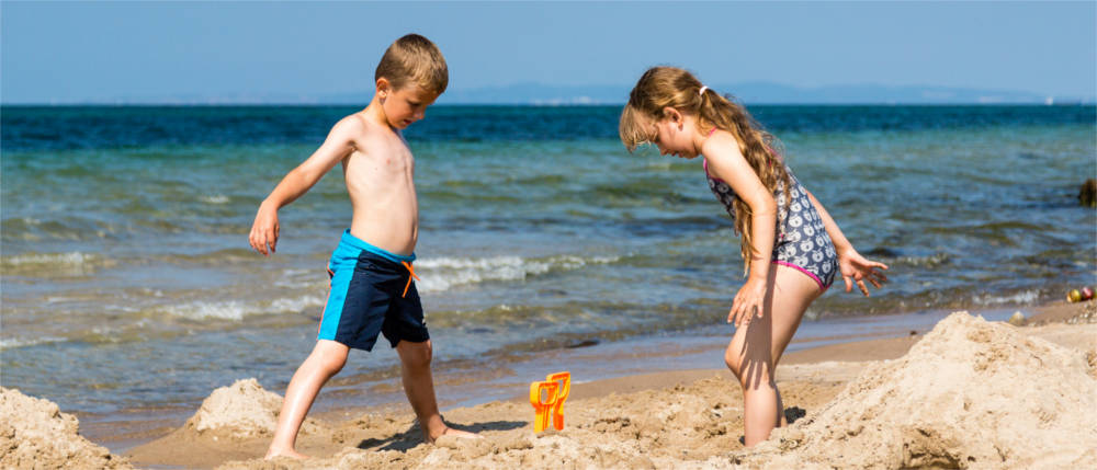 Kinder spielen am Strand 